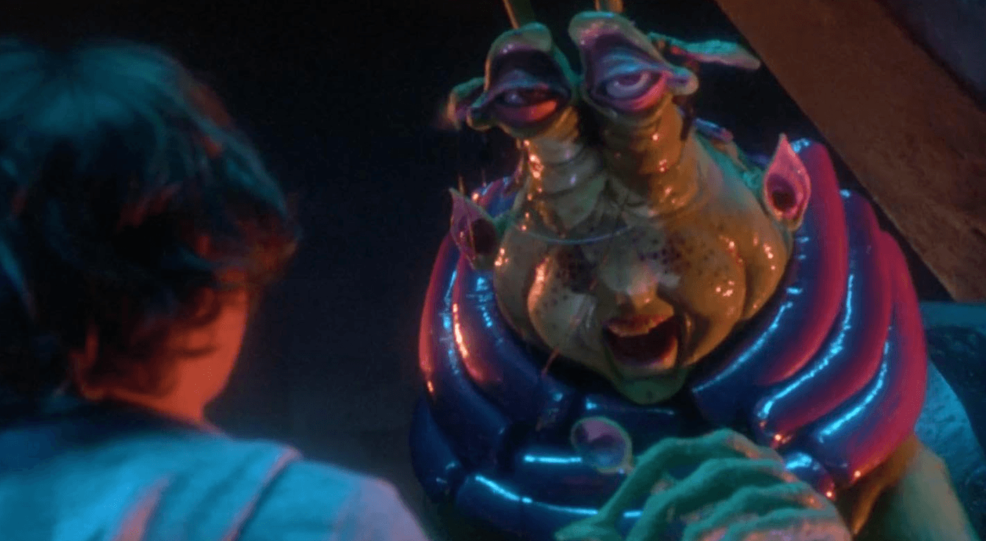 Screenshot of a scene from Explorers (1985) with Wak, a big floppy green alien