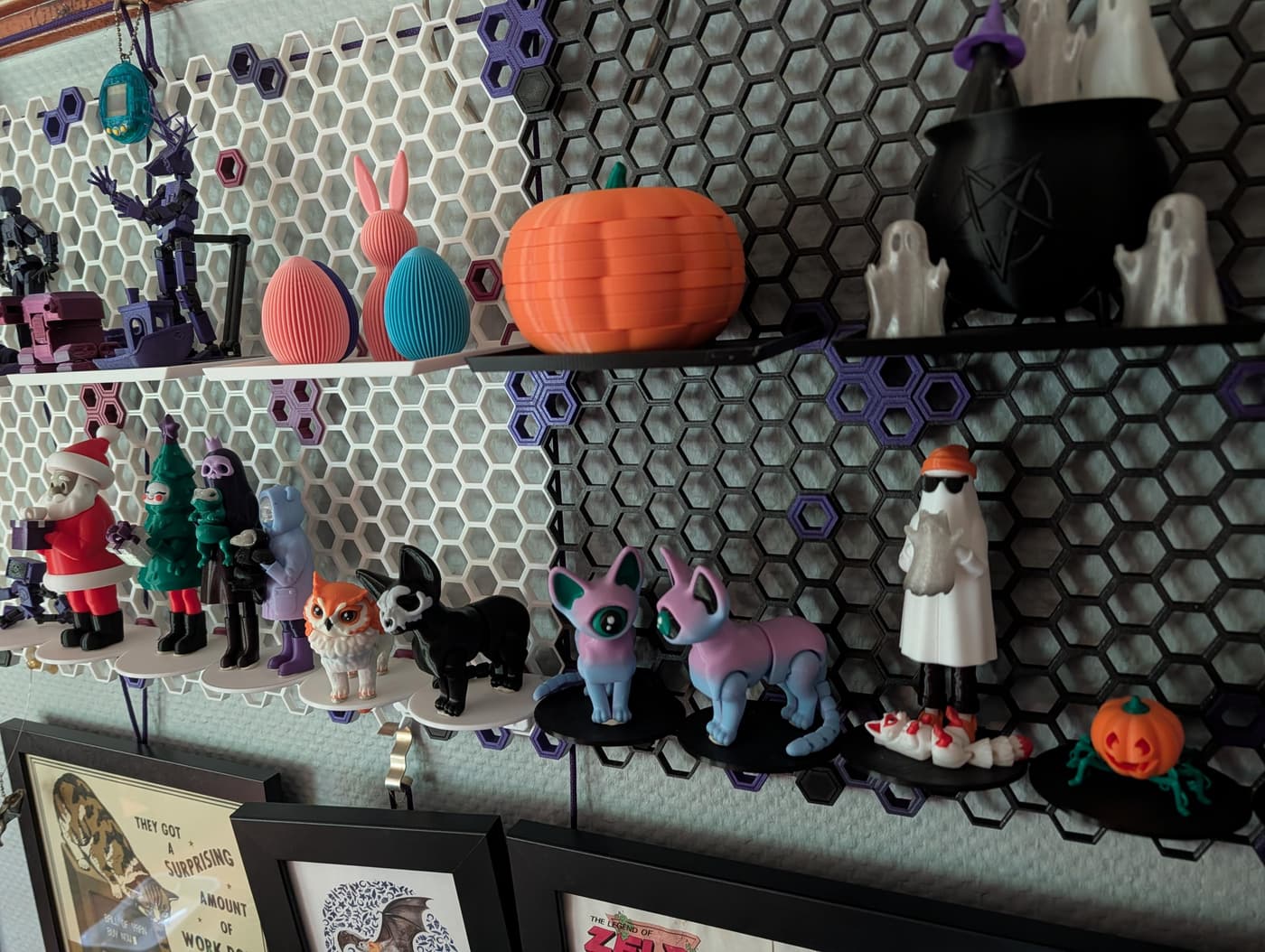 A wall of colorful 3D-printed objects: weird cats, a ghost, a santa, a tree-elf, and assorted oddities